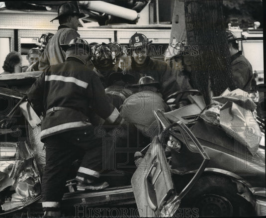 1993 Press Photo Rescue workers free two men, whose car struck a tree - Historic Images
