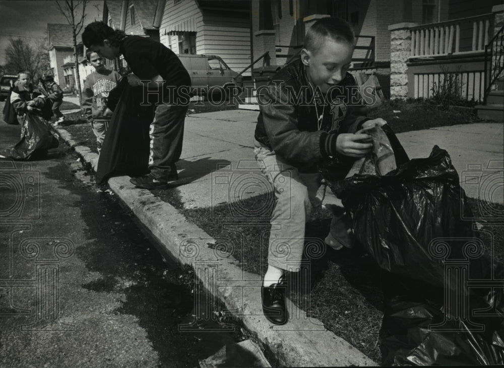 1993 Press Photo Patrick Hughes picks up trash at S. 25th and W. Rogers streets - Historic Images