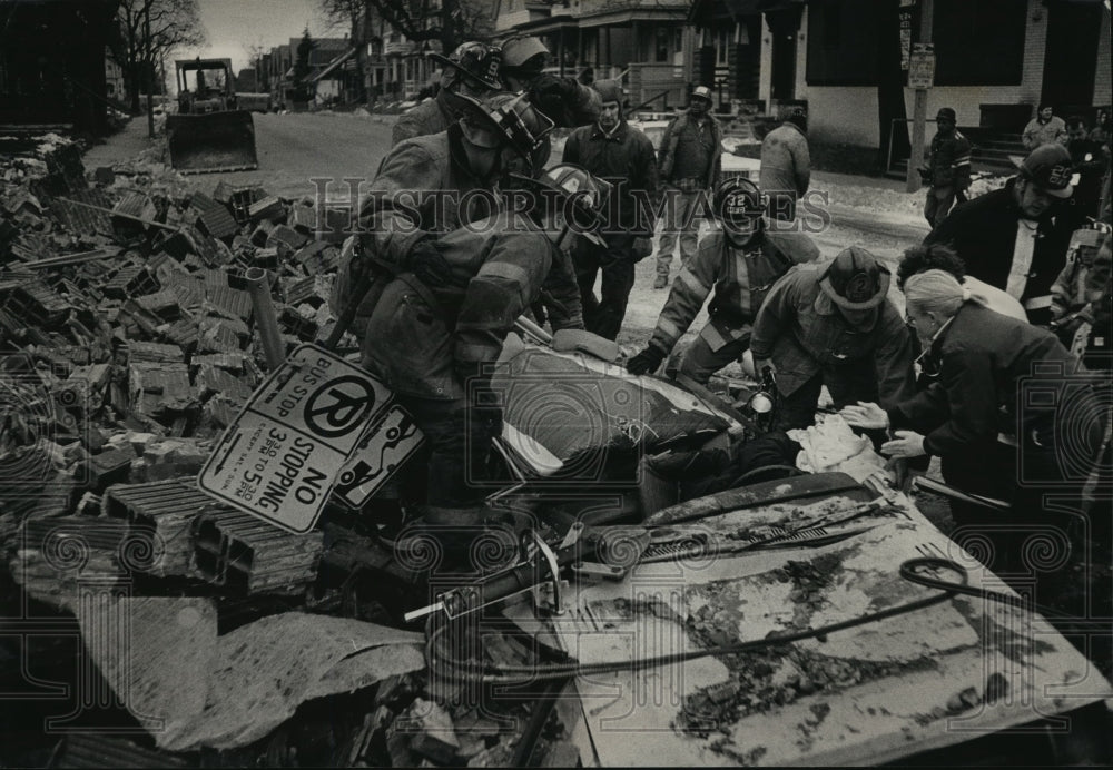 1990 Press Photo Firefighters rescue Richard Lerche after a brick wall collapsed - Historic Images