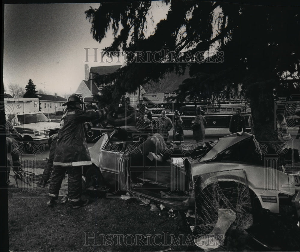 1990 Press Photo Firefighters clear up debris after car rammed a tree-Historic Images