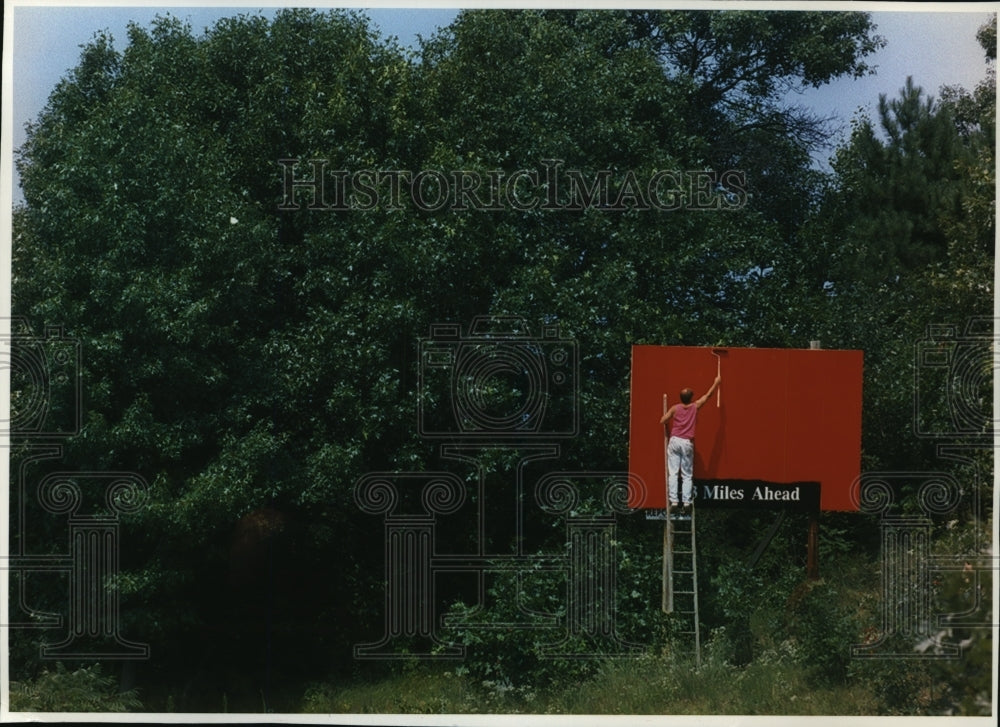 1994 Press Photo Robert Hufford freshens up billboard along State Highway 13 - Historic Images