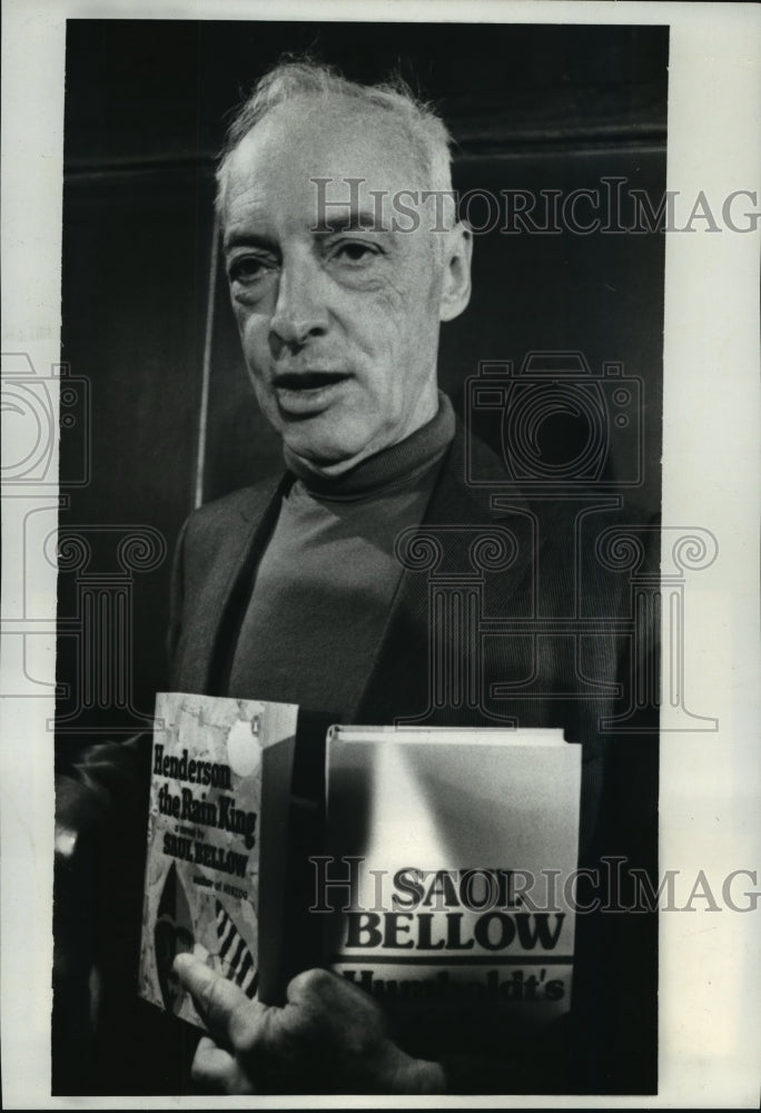 1976 Press Photo Novelist Saul Bellow holds copies of two of his works - Historic Images