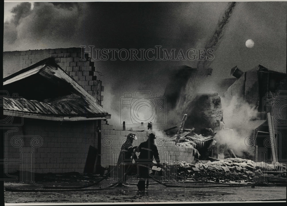 1992 Press Photo Firefighters begin removing hoses as a fire at Behnke Lumber Co - Historic Images