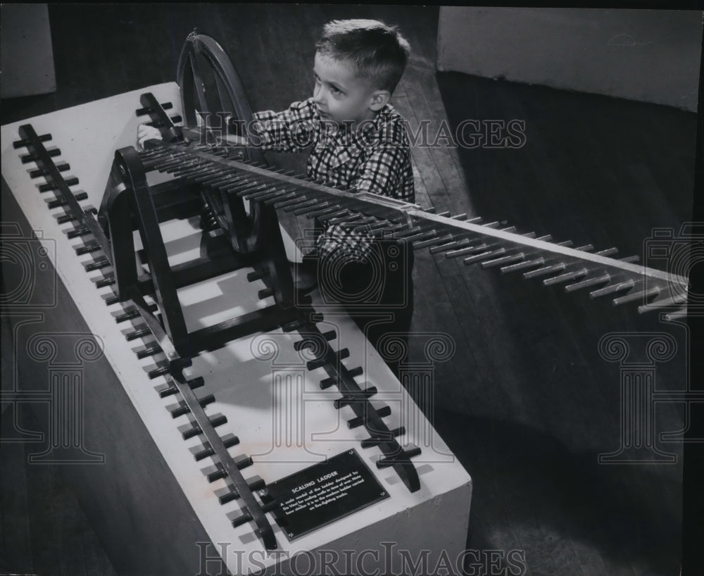 1955 Press Photo Daniel Stanley looking at a ladder Leonardo da Vinci invented - Historic Images