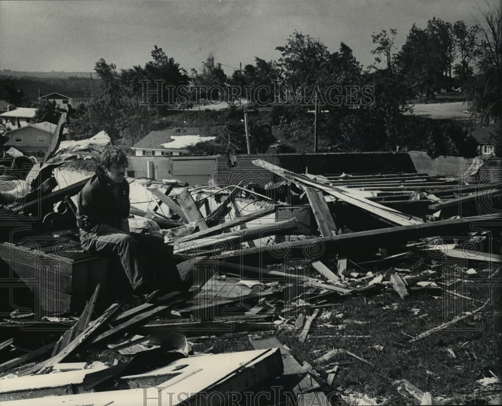 1984 Press Photo Man sits on a pile of rubble in Barneveld, Wisconsin - Historic Images