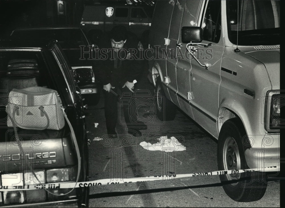 1992 Press Photo A police officer examines parking lot of TGI Friday&#39;s-Historic Images