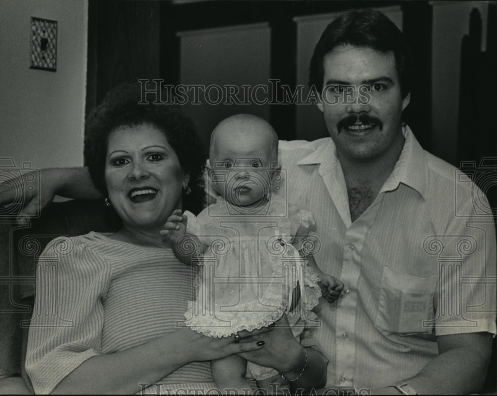 1984 Press Photo A wide-eyed Melisa Purdy sat with her parents, Cecile and David-Historic Images