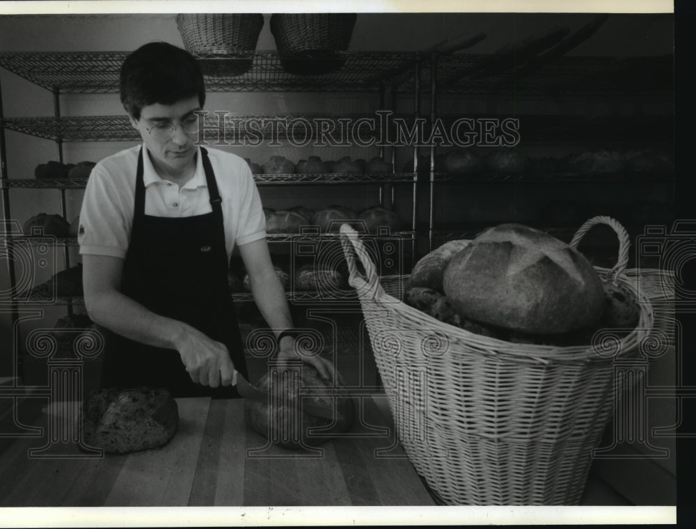 1993 Press Photo Dan Sterling cuts a loaf of boule for customers to sample-Historic Images