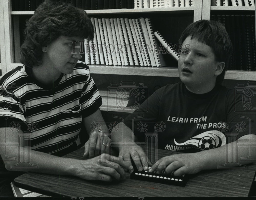 1990 Press Photo Teacher Becky Cauffman assists Gregg with a math problem - Historic Images