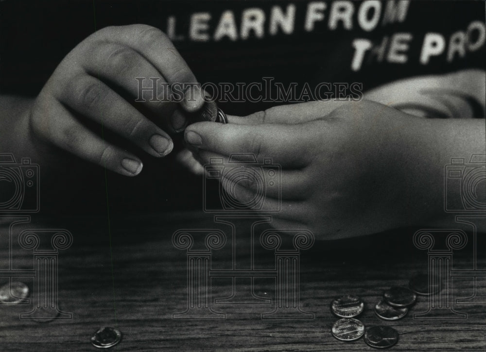 1990 Press Photo Gregg counts coins by feeling the edges and determining size - Historic Images