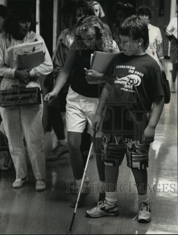 1990 Press Photo Gregg Wandsneider makes his way down a crowded school corridor - Historic Images