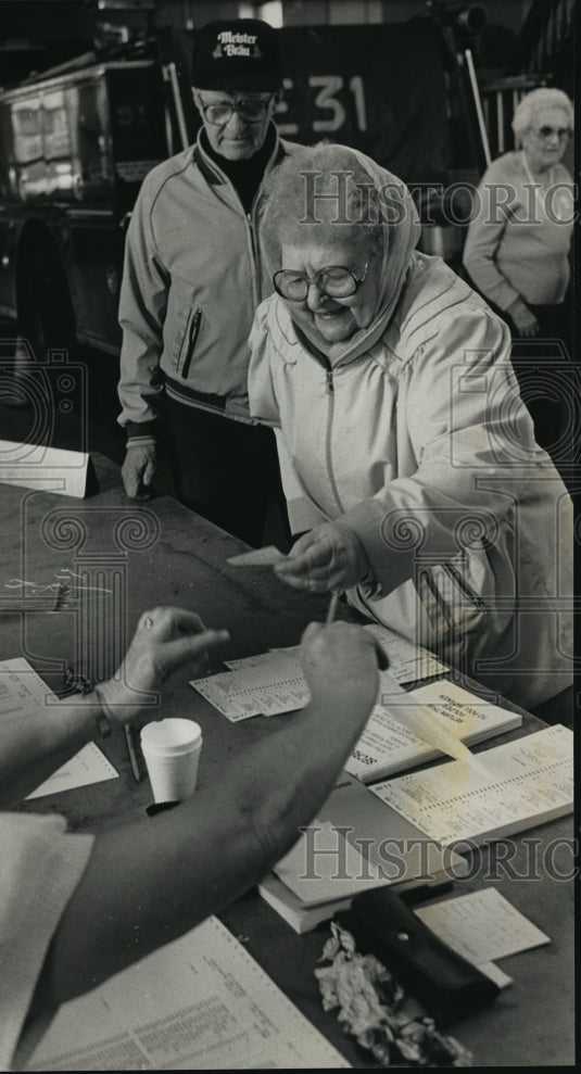 1989 Press Photo Lois Dobrzynski picks up a ballot at Milwaukee fire station-Historic Images