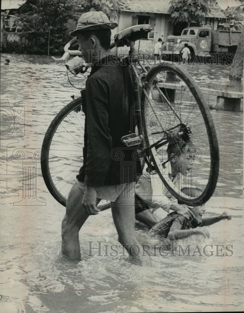 1966 Press Photo Man sloshed through floodwater in village near Cambodian border - Historic Images