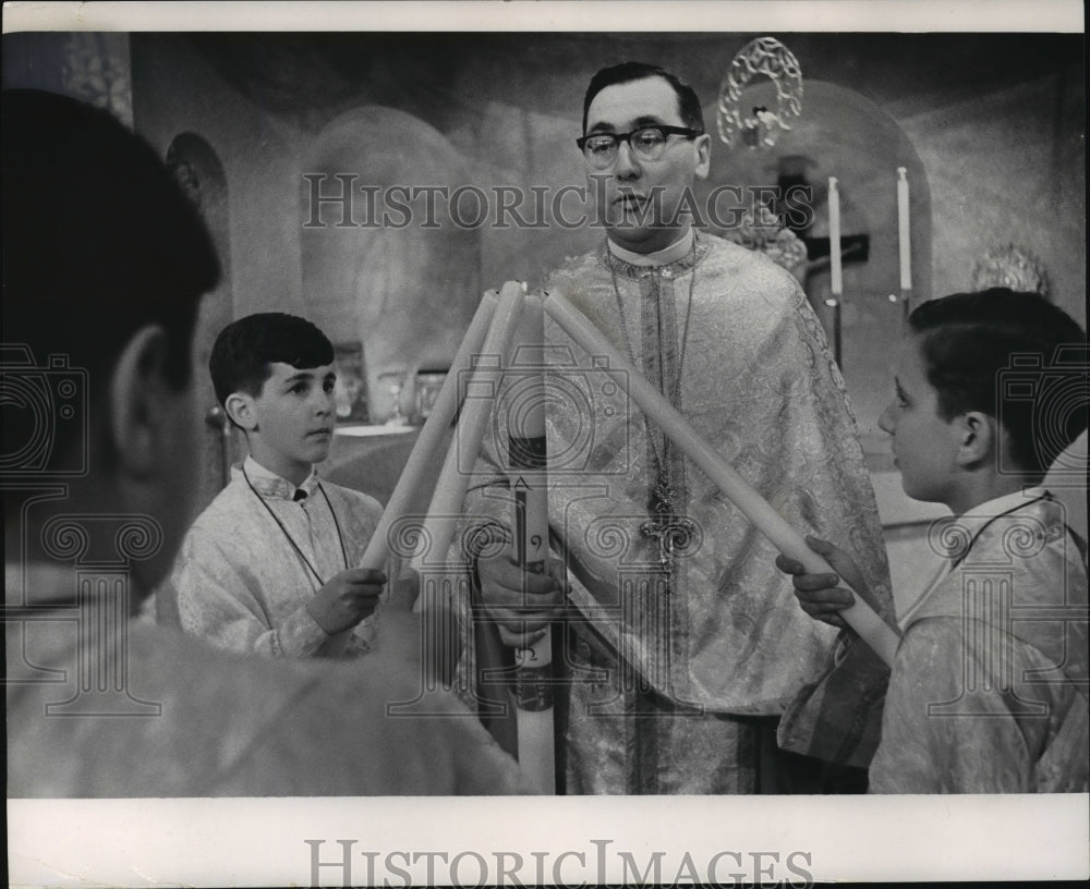 1966 Press Photo The Rev. E.N. Vergis demonstrates the lightnings of candles - Historic Images