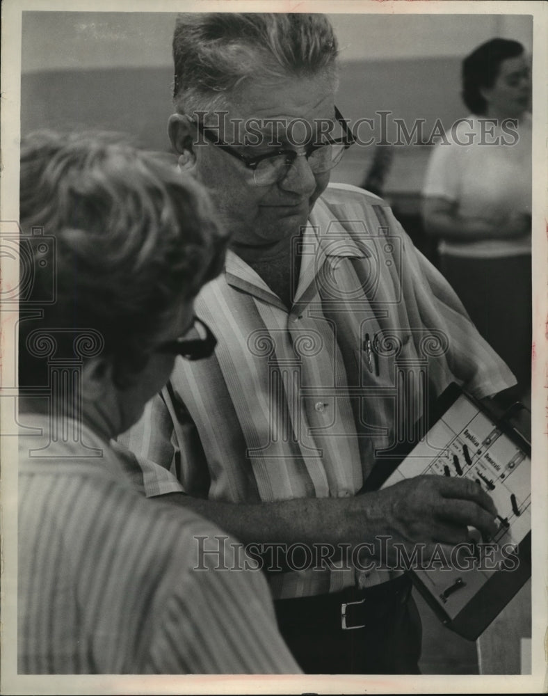 1966 Press Photo Lawrence A. Buchholz, used a small model of a voting machine - Historic Images