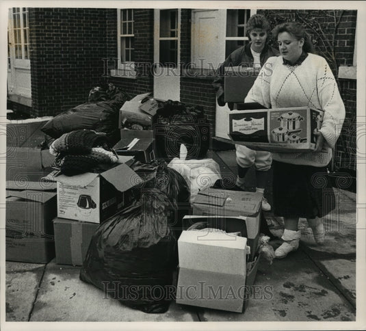 1988 Press Photo J. Carlock & L. Krause organize clothing pile at Caroll College - Historic Images