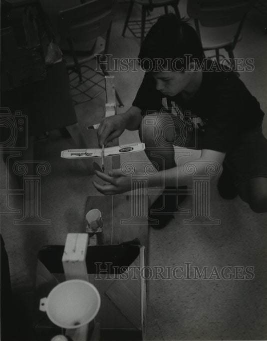 1994 Press Photo Jeremiah Moll winds up the prop on a plane- energy conservation - Historic Images