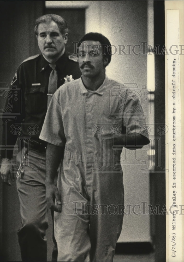 1986 Press Photo Wilbert Wesley is escorted into courtroom by a sheriff deputy - Historic Images