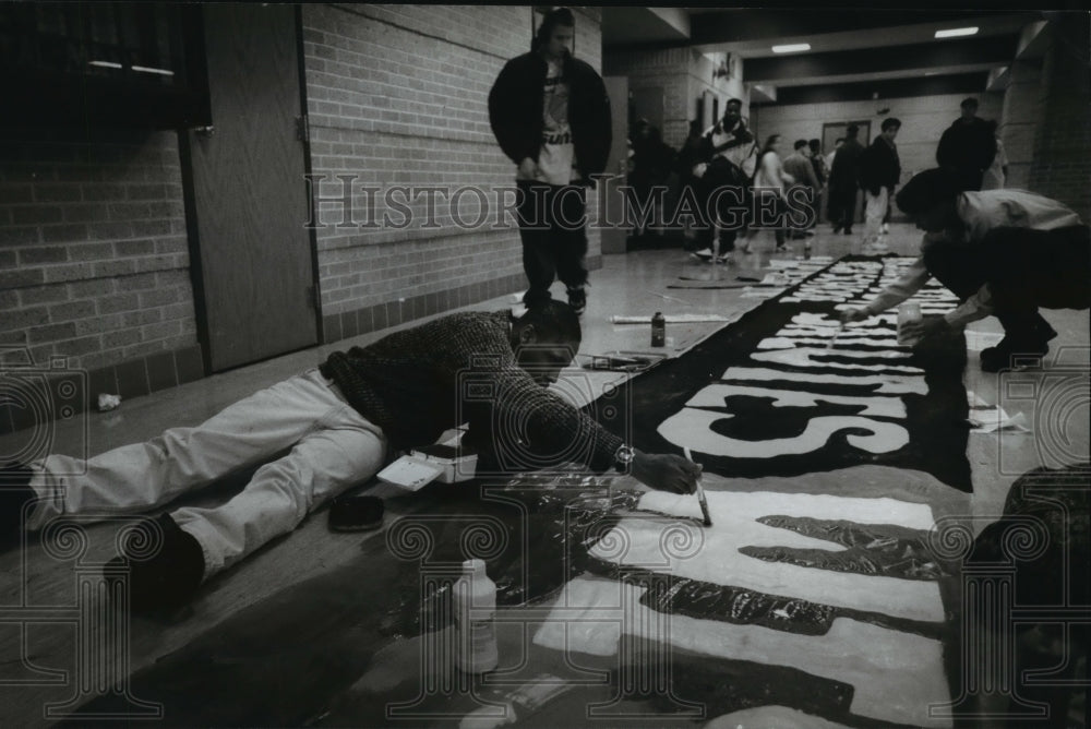 1994 Press Photo Daniel Powell, 17 works on a banner welcoming the president - Historic Images