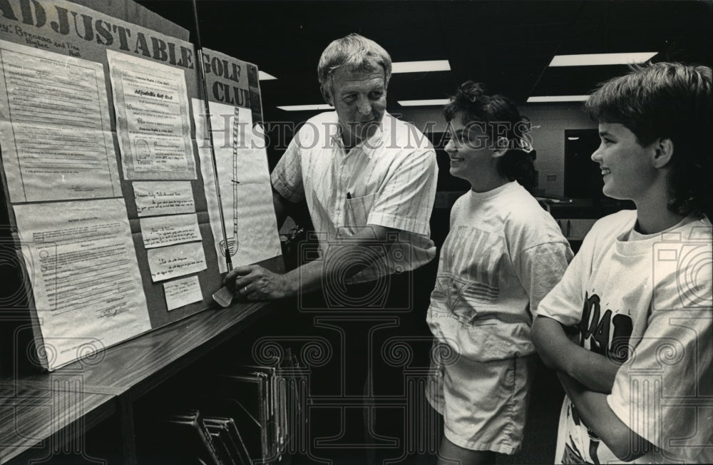 1988 Press Photo Tom Graf inspects a golf club created by B. Higbee and T. Hall - Historic Images