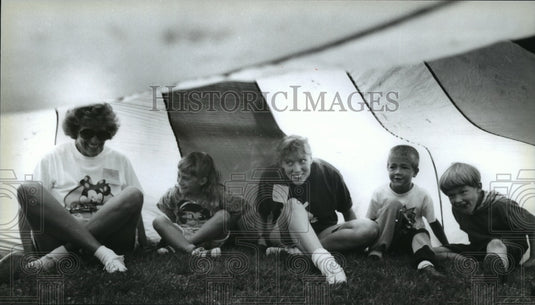 1994 Press Photo Donna Sommers sits under a parachute with a parent & pupils - Historic Images