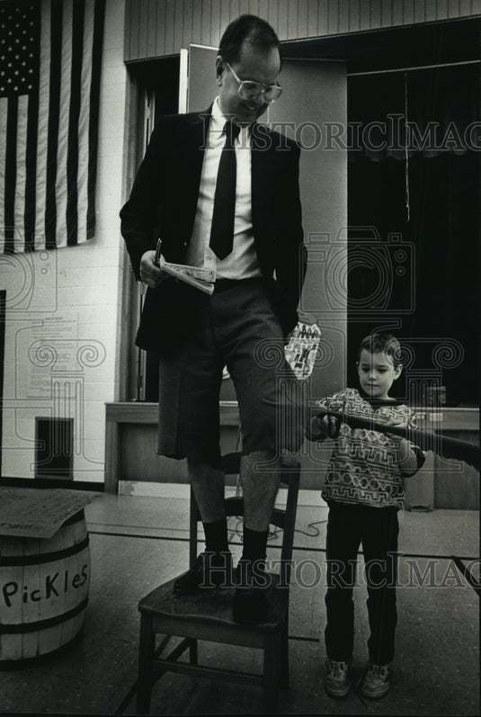 1990 Press Photo Casey Carlsen cutting Principal Dale Heinen's pants - mja25799 - Historic Images