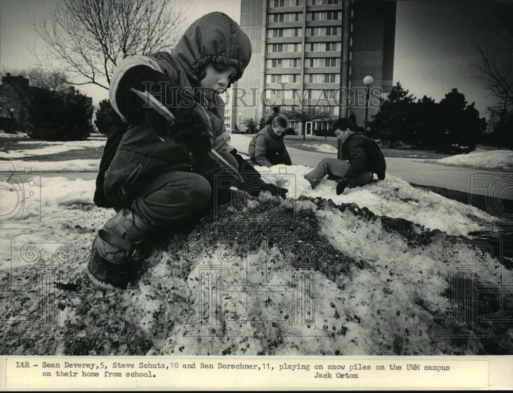 1986 Press Photo Susan Deverey, Steve Schultz playing on the snow on UWM Campus - Historic Images