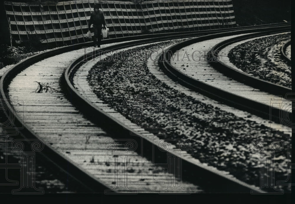 1992 Press Photo Man walks along the railroad tracks while snowing - mja26379 - Historic Images