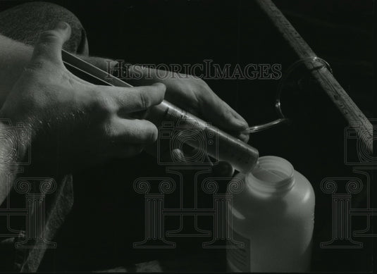1993 Press Photo Water from the syringe is inserted into a plastic bottle - Historic Images