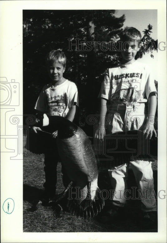 1992 Press Photo Calan and Cass Edwards stand next a wood carved goose-Historic Images