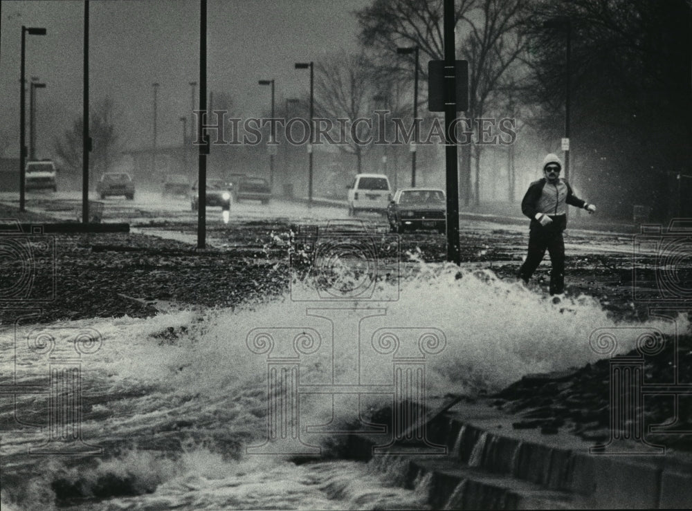 1985 Press Photo A jogger dodged waves of Lake Michigan onto Lincoln Memorial Dr-Historic Images