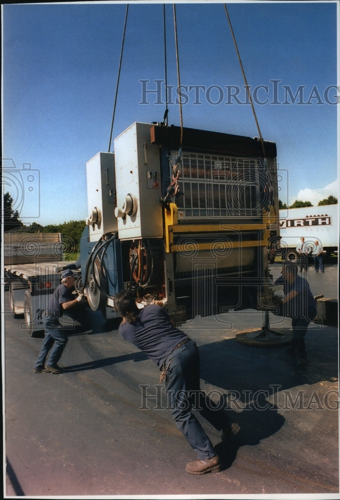 1994 Press Photo Workers helping a crane lower a five-section press - mja34343-Historic Images