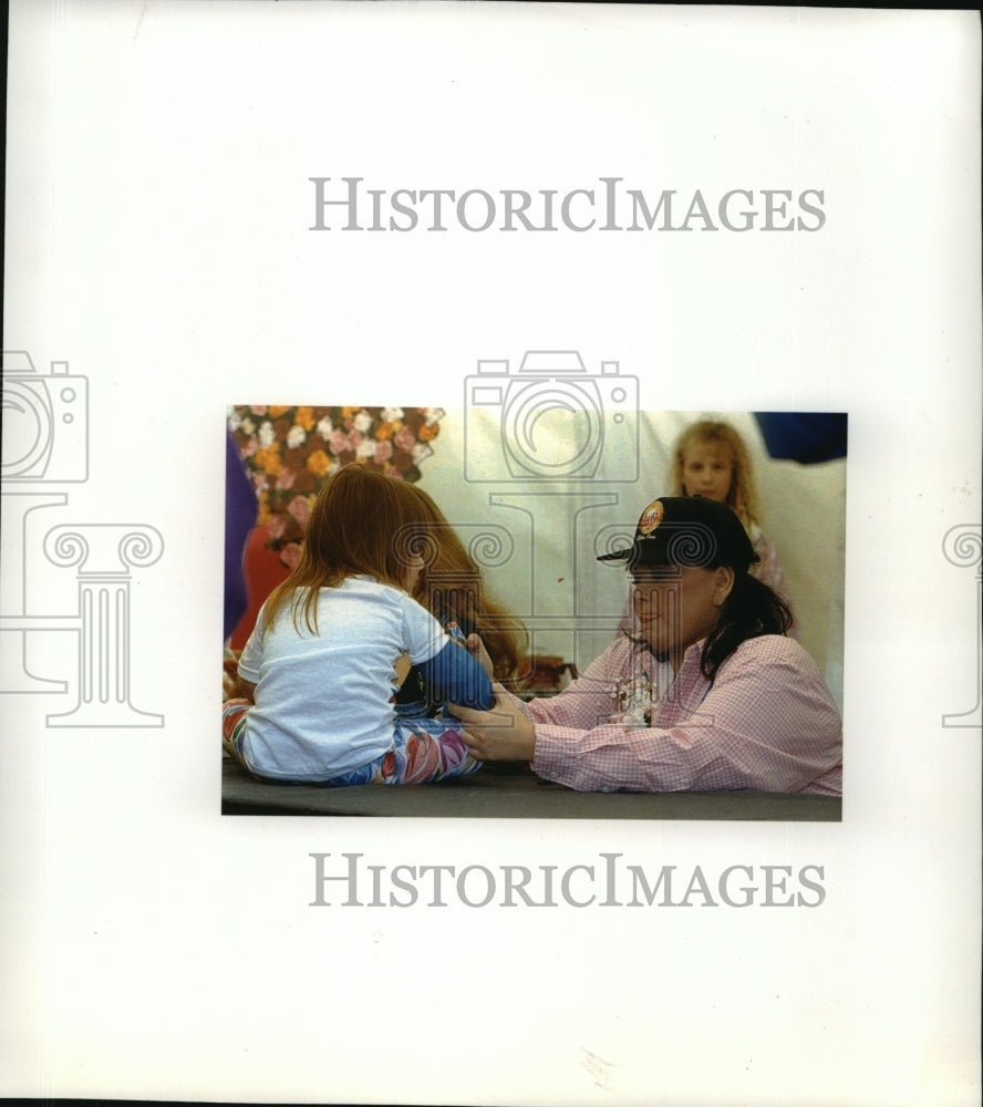 1994 Press Photo Roseanne Arnold signs child&#39;s cast in Eldon, Iowa - mja34661-Historic Images