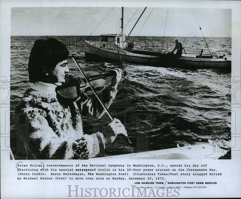 1973 Press Photo Miran Kojian of National Symphony plays violin on his cruiser-Historic Images