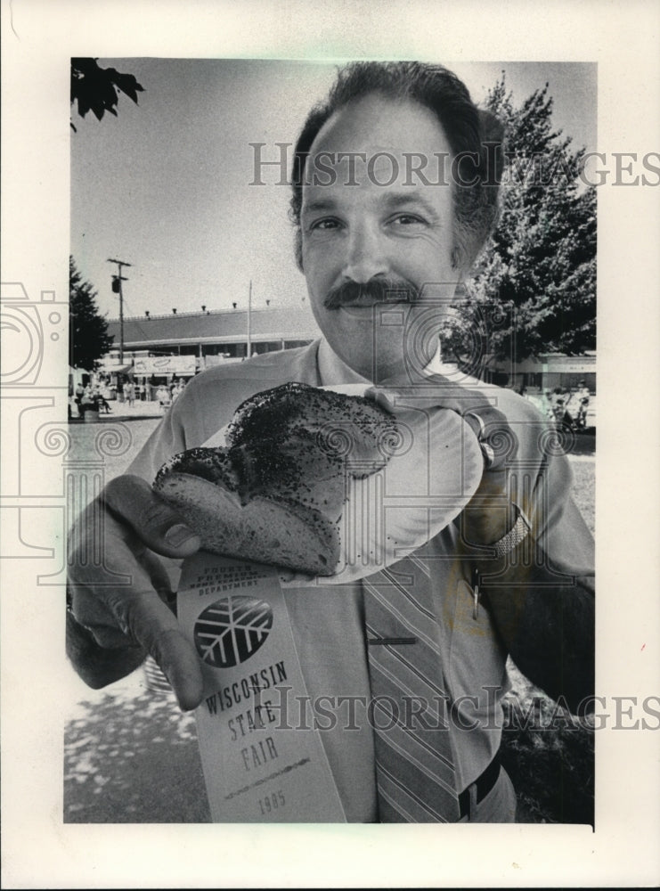 1985 Press Photo Robert D. Tigar shows his winning loaf of bread, Wisconsin Fair - Historic Images