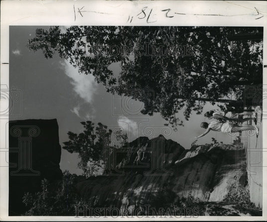 1957 Press Photo Girls wondered over the height of a formation near Stand Rock-Historic Images