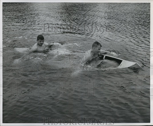 1960 Press Photo Larry Garcia, James Anderson Paddle Water-Filled Canoe To Shore-Historic Images