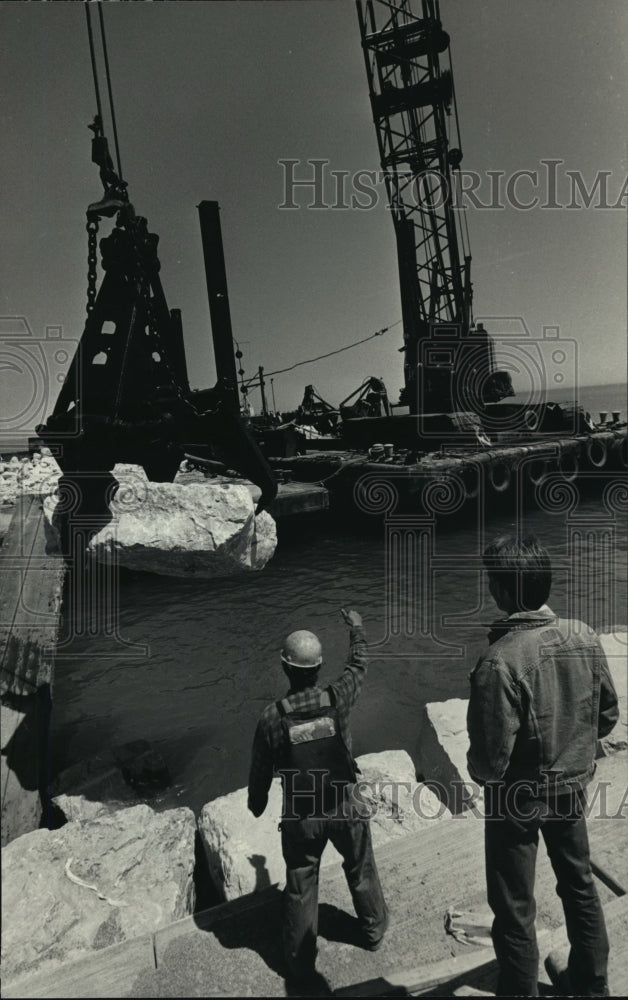 1987 Press Photo Construction workers lower limestone to Lake Michigan Shoreline - Historic Images