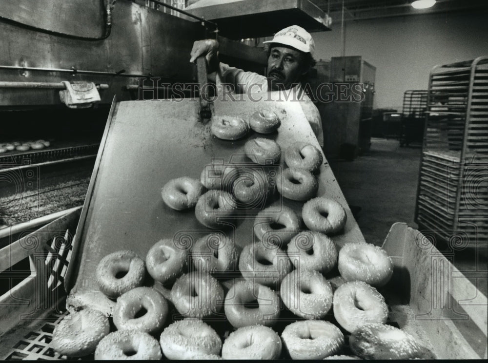 1993 Press Photo Baker Francisco Ferrusquia removes hot bagels from the oven - Historic Images