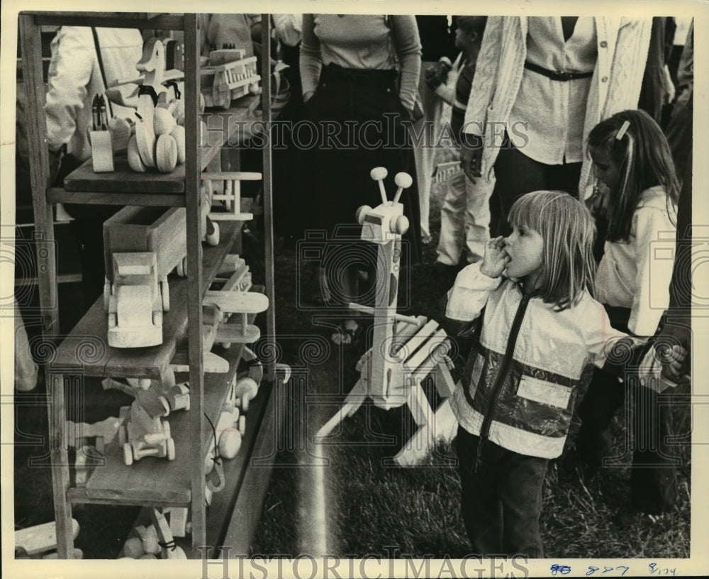 1979 Press Photo Girl admiring toys by Woodstock Toymaker at Lakefront Festival-Historic Images