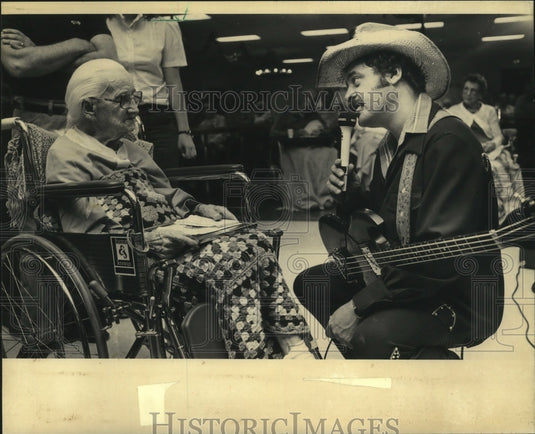 1963 Bruce Russell sings to Kathy Zimmerman at a nursing home - Historic Images