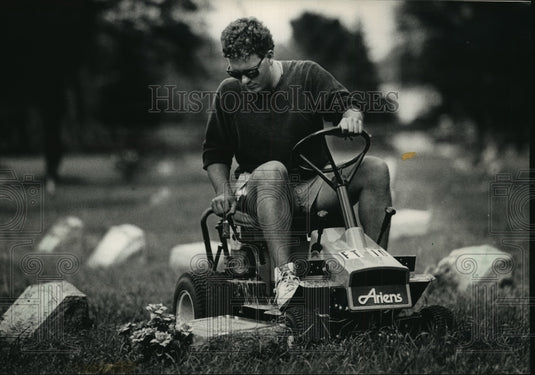 1988 Press Photo Gary mows grass at Lincoln Memorial Cemetery, Milwaukee, WI - Historic Images