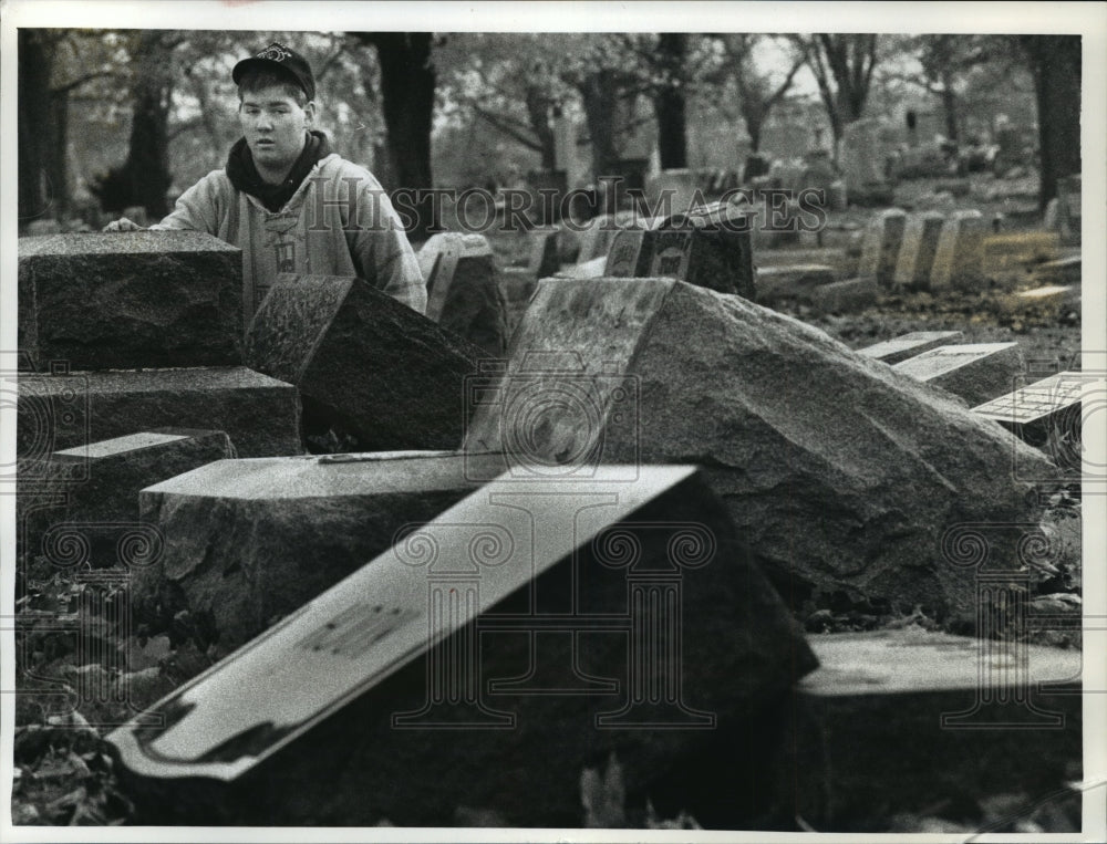 1992 Press Photo Worker at Lincoln Memorial Cemetery looking at vandalized grave - Historic Images