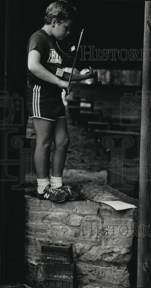 1990 Press Photo Andrew Gavin Stands On Rocky Perch With Violin at Camp Onaway - Historic Images