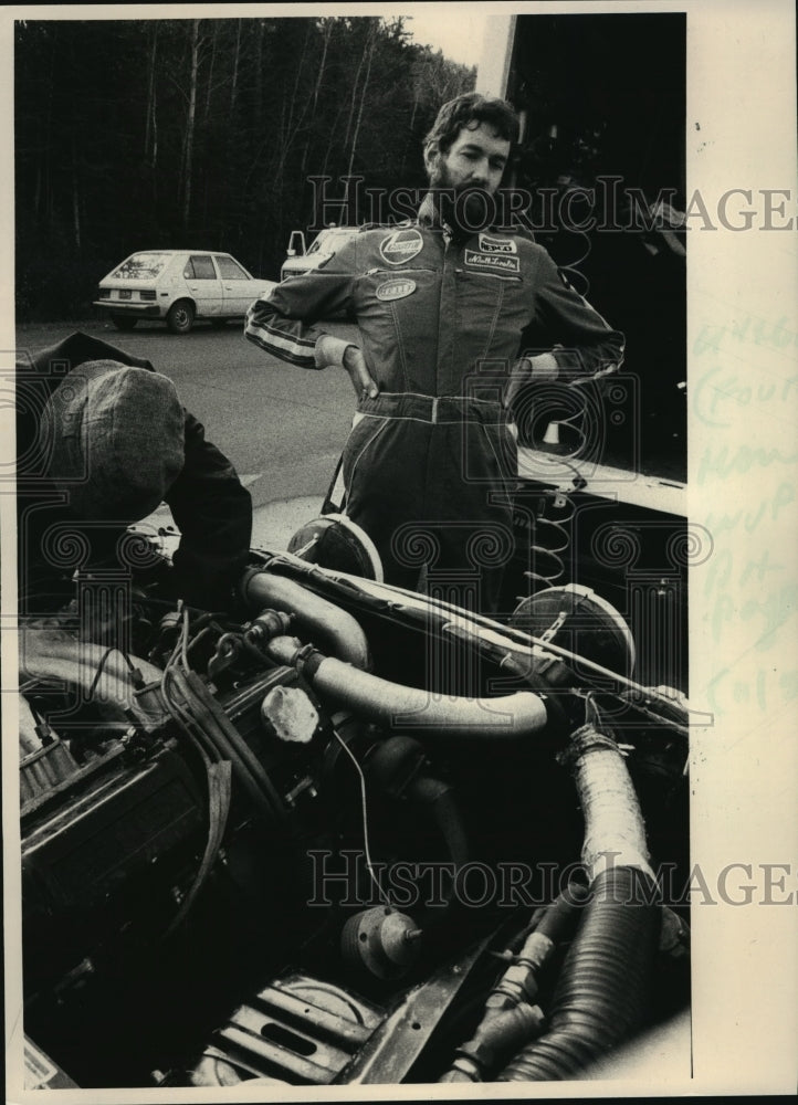 1984 Press Photo Racing-Driver Neil Leslie Rests while Service Crew Tackle Car-Historic Images