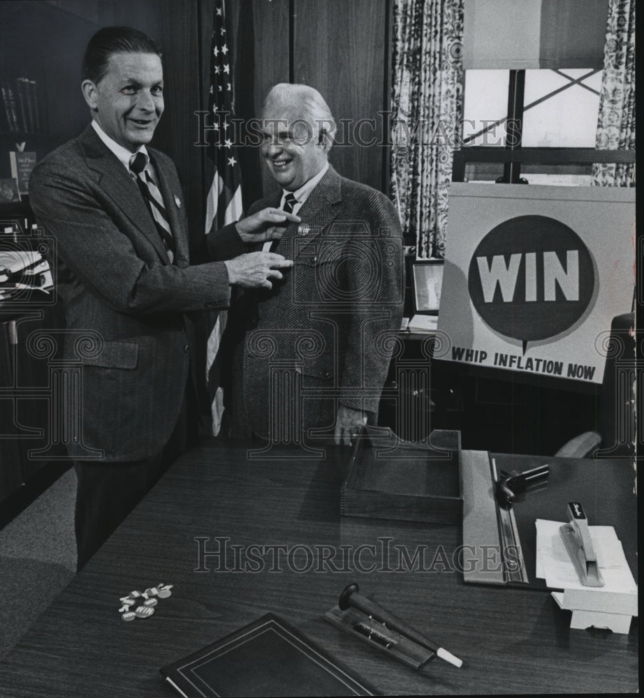 1974 Robert Brown pins a WIN button on County Executive Doyle - Historic Images