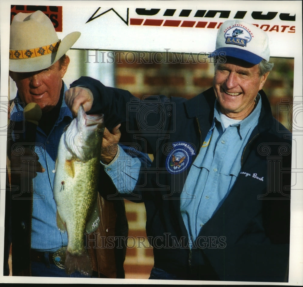1993 Press Photo George Bush holds a 5 pound 4 ounce bass he caught in Alabama-Historic Images