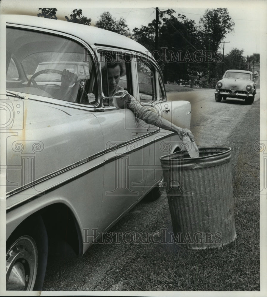 1961 Press Photo Women dropping a alcohol bottle in garbage can - Historic Images