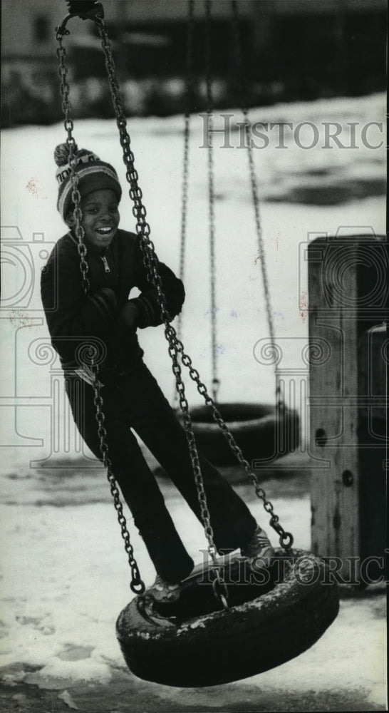 1983 Press Photo Ronald Williams plays on a tire swing, Milwaukee - mja65805 - Historic Images