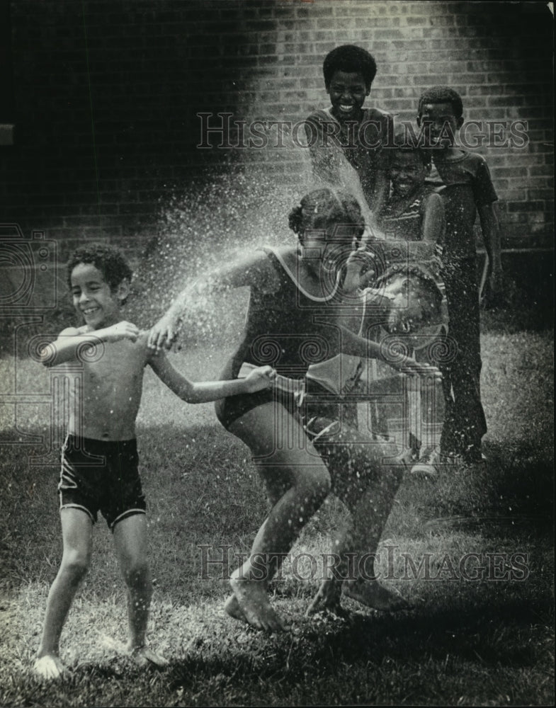 1980 Press Photo Children cooling off by the spray of a hose - mja66083-Historic Images